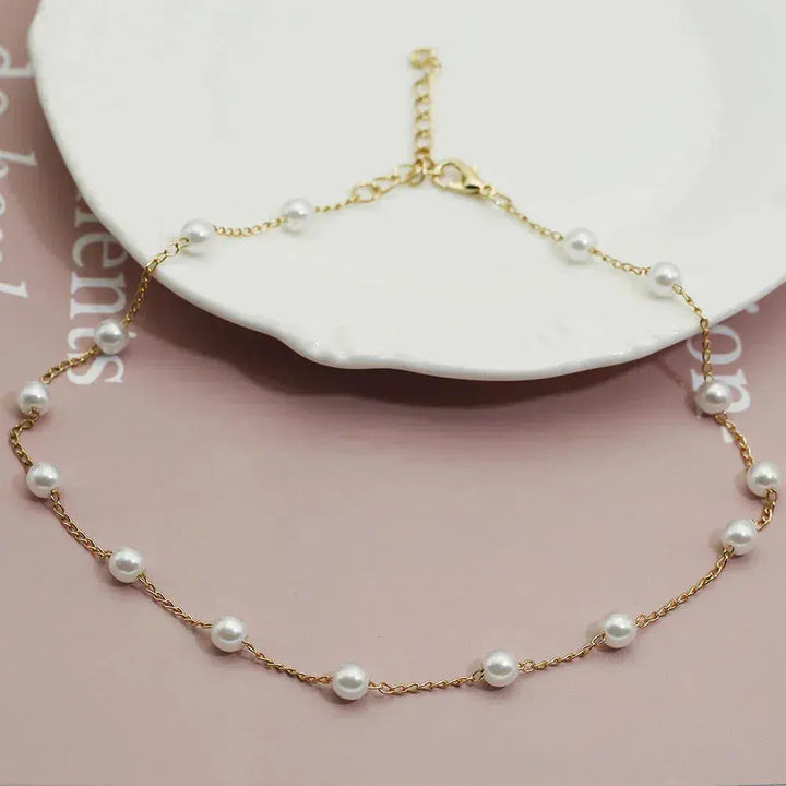 "Elegant Guldhalsband med Pärlor" can be rewritten as "Stiligt Guldhalsband med Pärlor".