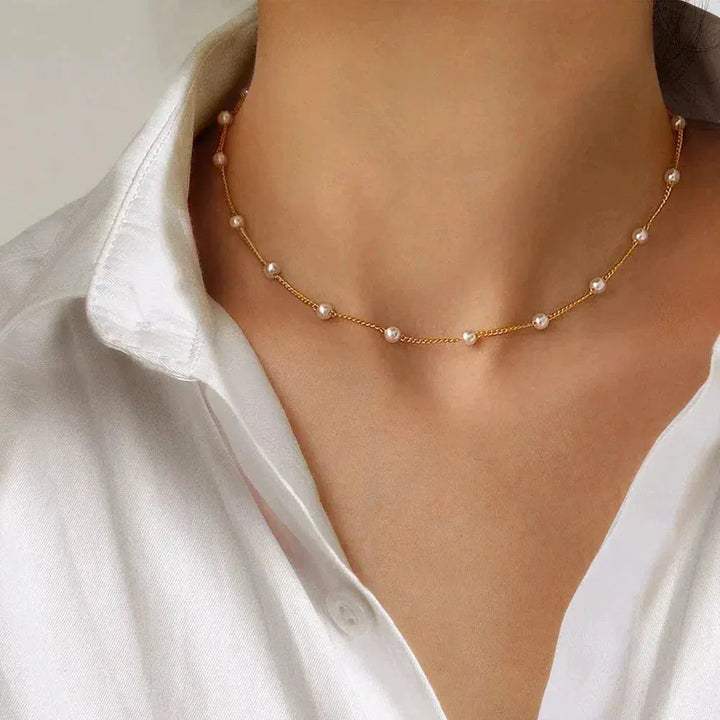"Elegant Guldhalsband med Pärlor" can be rewritten as "Stiligt Guldhalsband med Pärlor".