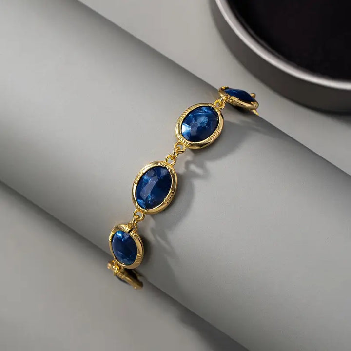 Skinande Guld Saphir Armband" could be rewritten as "Radiant Gold Sapphire Bracelet.