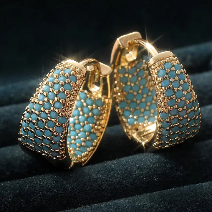 Eleganta hängande örhängen i guld med turkosa pärlor